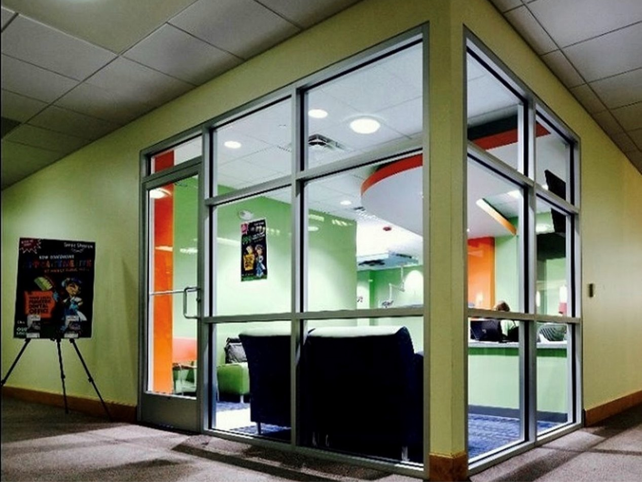corner with windows looking into the reception and front desk area of office